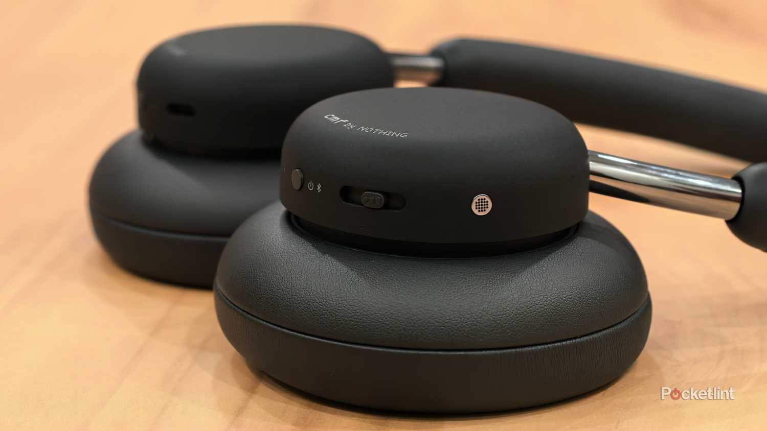 Close up shot showing CMF Headphones Pro's power button and MIc