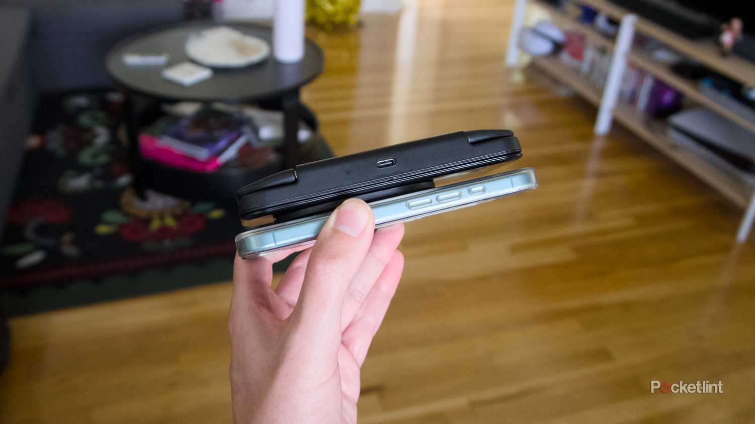 An MCON controller magnetically attached to the back of an iPhone 16.