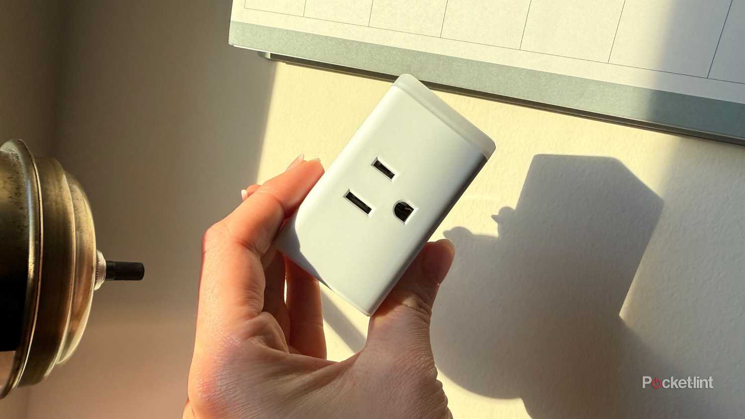 Sosteniendo un Kasa Smart Plug. 