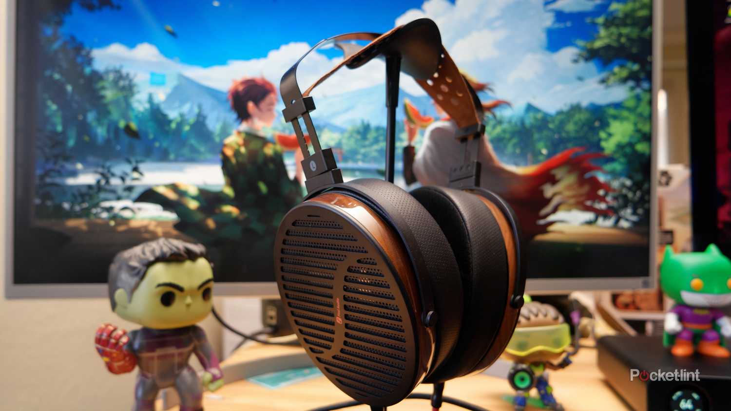 The Fosi Audio i5 Planar Magnetic headphones on a desk with Funko Pop figurines