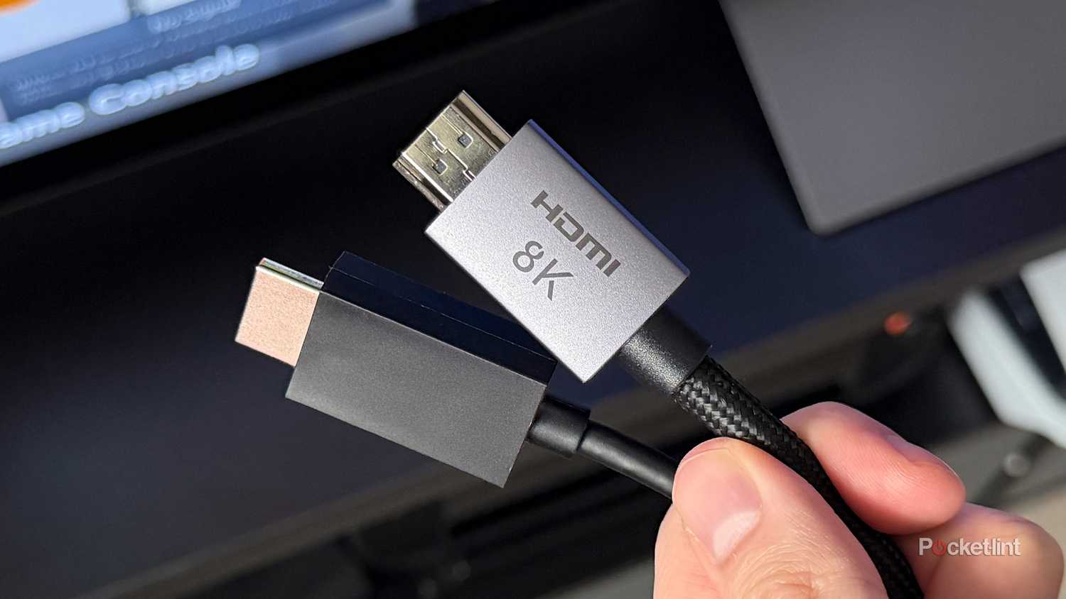 Person holding two HDMI cables.