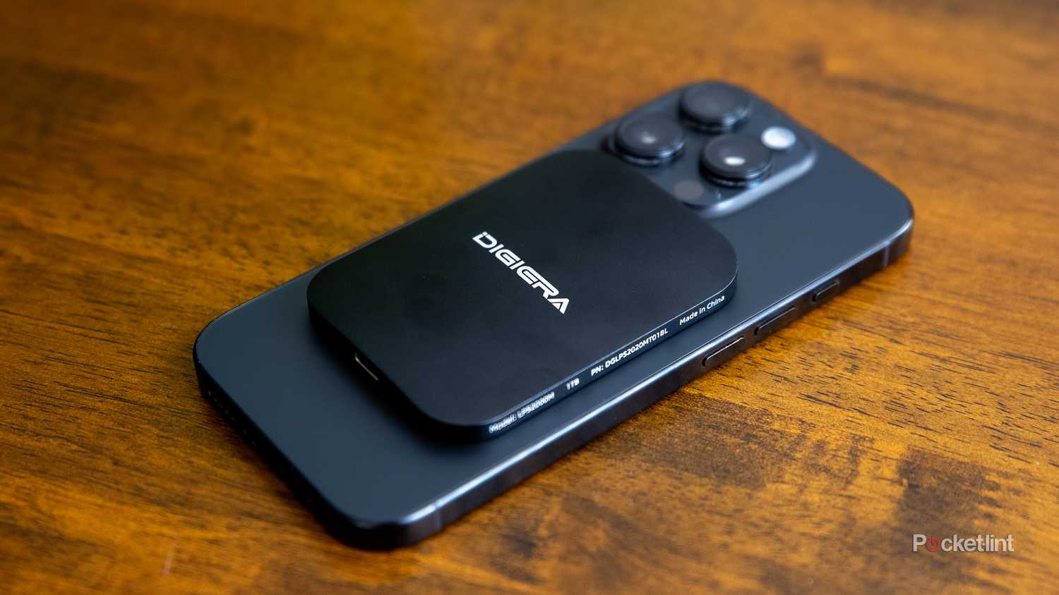 A still photo of the Digiera Endura SSD stuck to the back of an iPhone 16 Pro. 