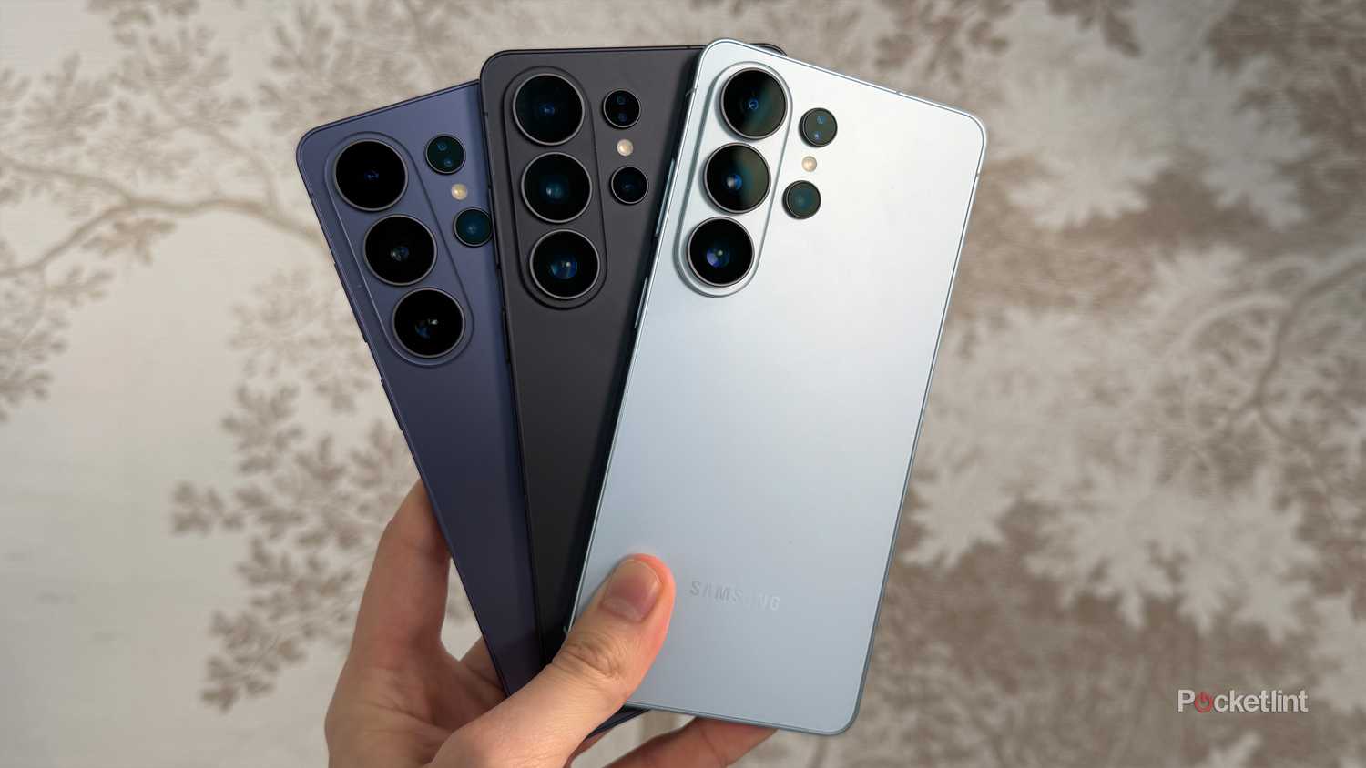 Person holding three Galaxy S26 Ultras.