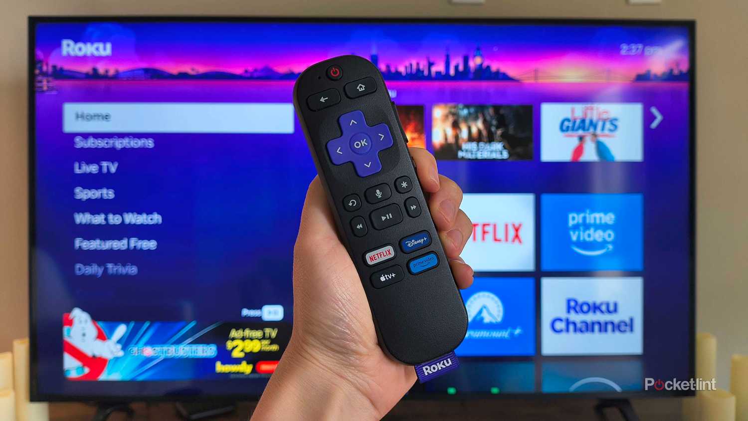 A Roku remote in front of the home screen. 