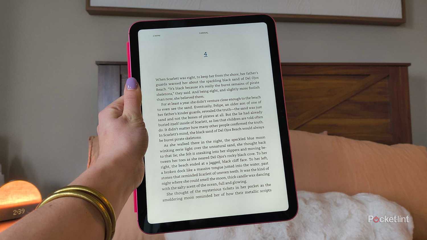 An iPad in front of a bed. 
