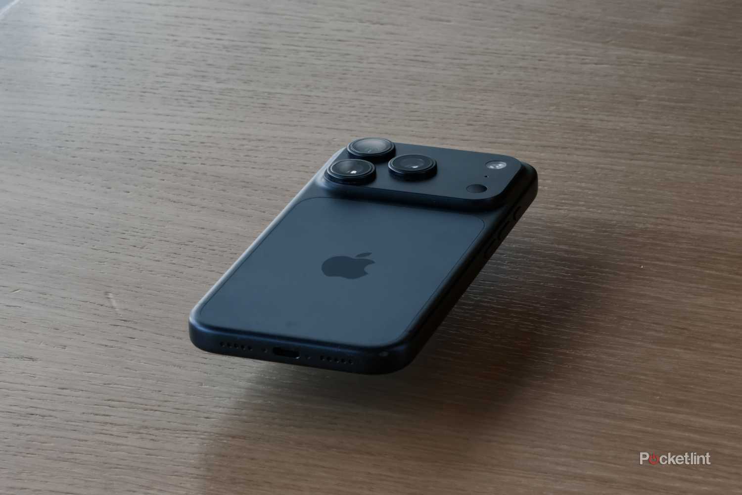 iPhone 17 Pro floating on wooden table