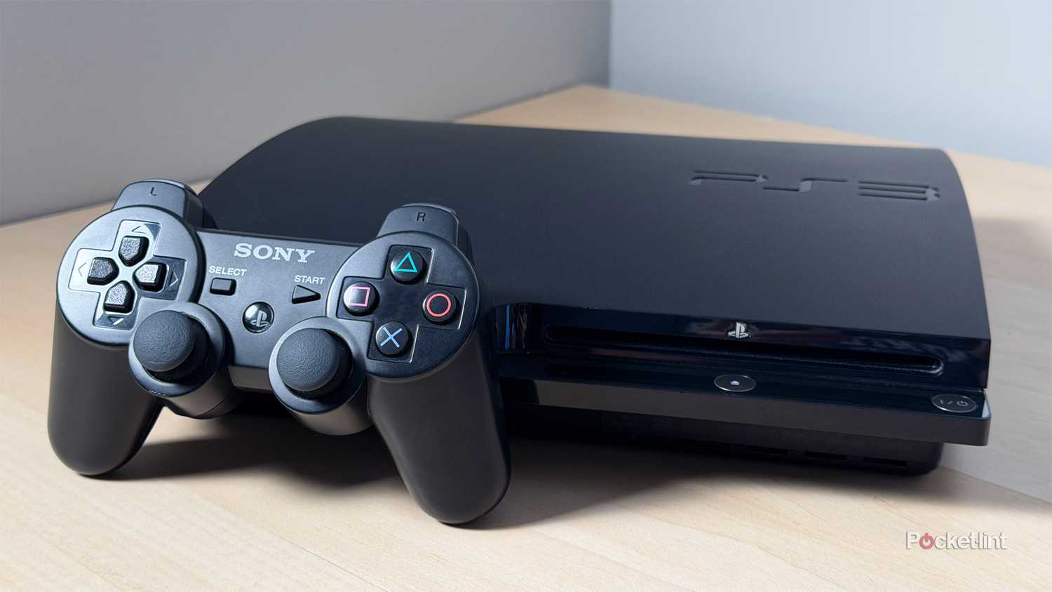 PlayStation 3 console on desk with controller.