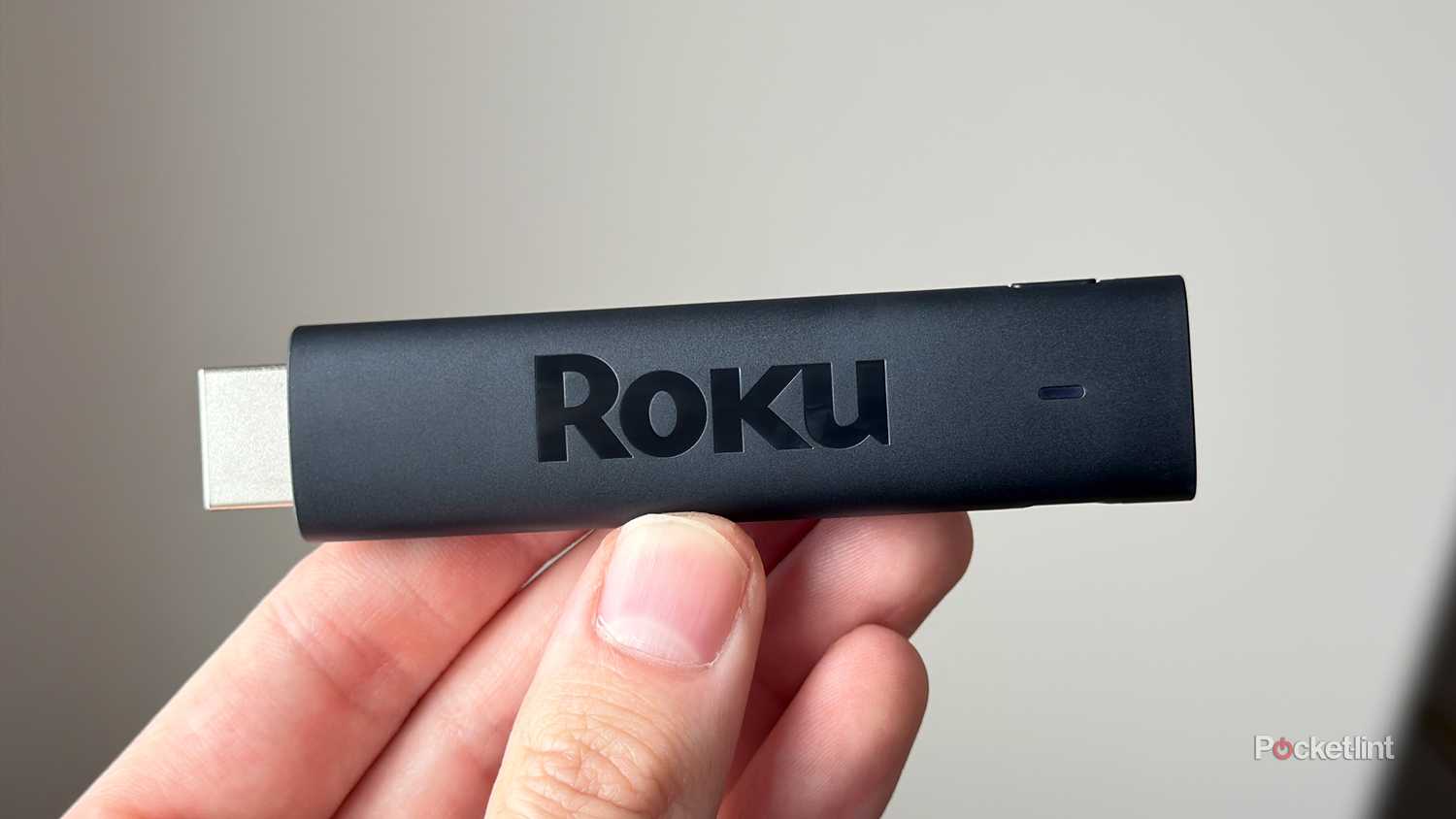 Person holding Roku Streaming Stick.