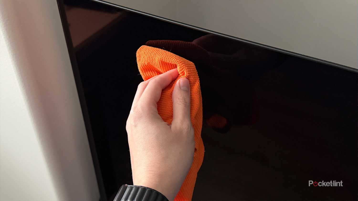 Person cleaning OLED screen.