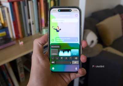 A hand holding an iPhone 16 displaying the Monologue keyboard.