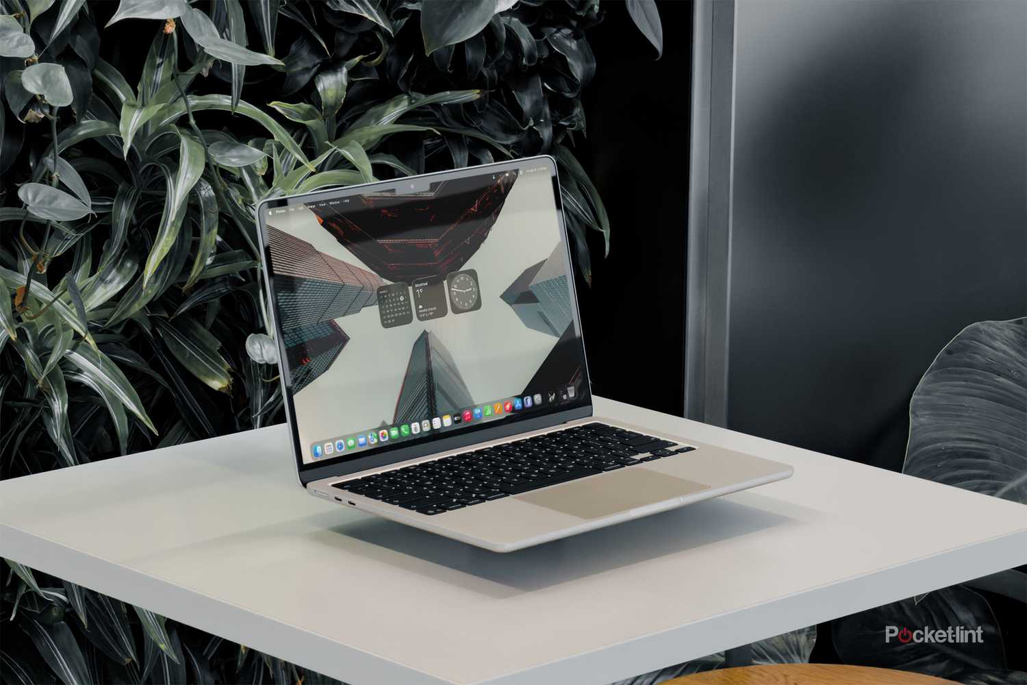 MacBook Air with M5 floating on a white table with screen on against foliage