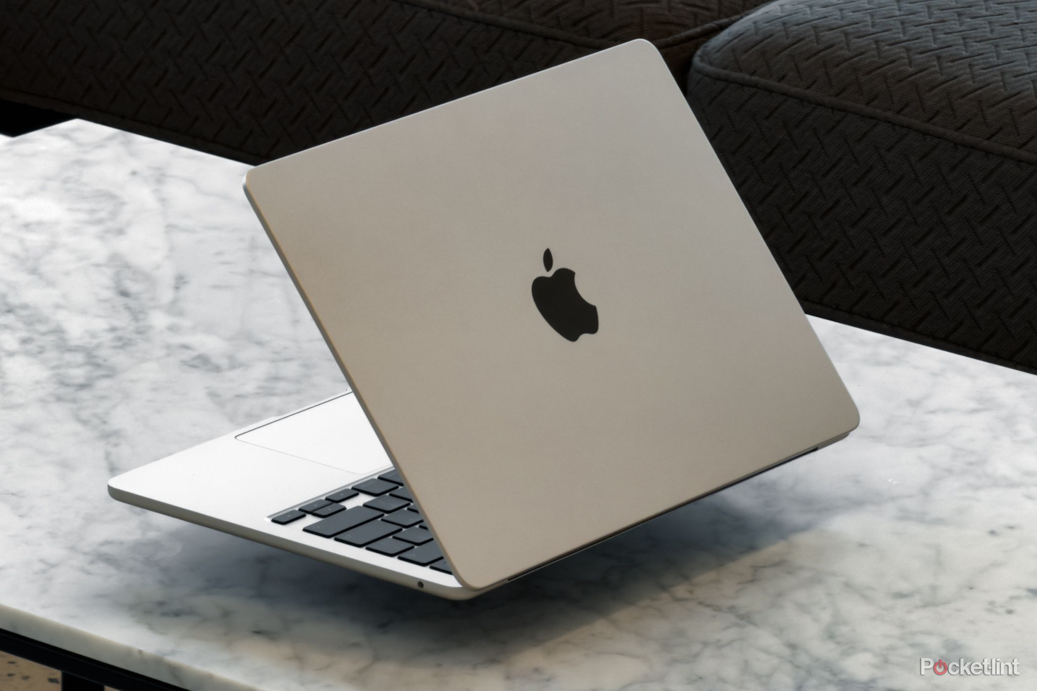 MacBook Air with M5 on top of a white table ahead of a couch