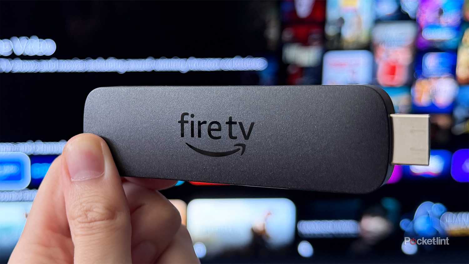 Person holding Fire TV Stick 4K Max in front of TV.