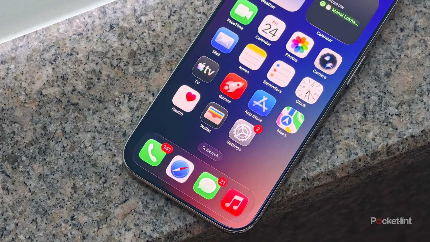 iPhone home screen with app icons and widgets on a granite surface