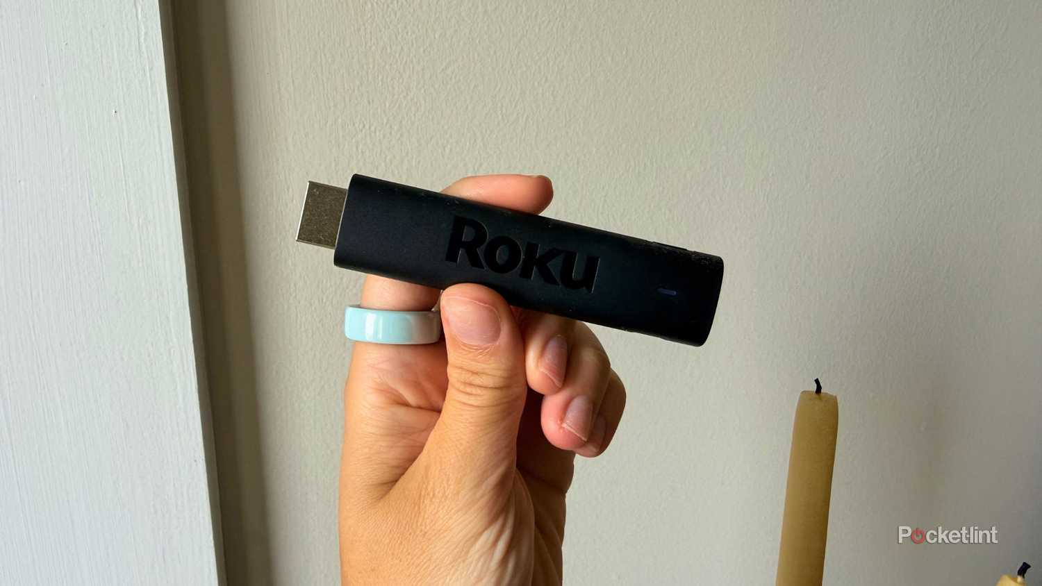 Roku streaming stick in hand. 