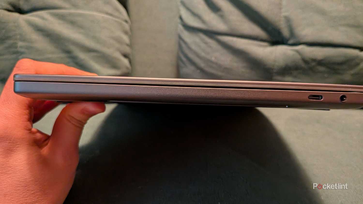 Person holding a closed Dell XPS 14 laptop.