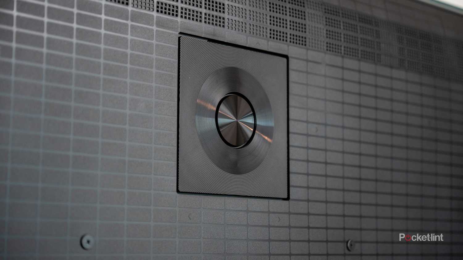 Close-up of the circular brushed-metal center speaker on the rear panel of the Hisense U7.