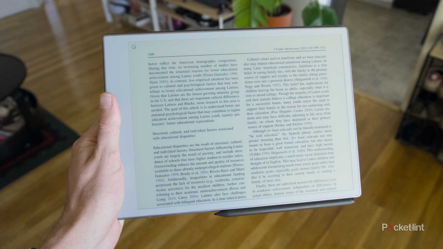 A hand holding a horizontal reMarkable Paper Pro.
