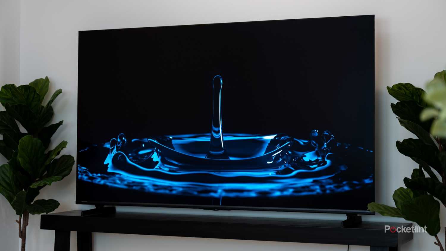 Hisense U6 on TV stand displaying a blue-lit water droplet splash with deep blacks.