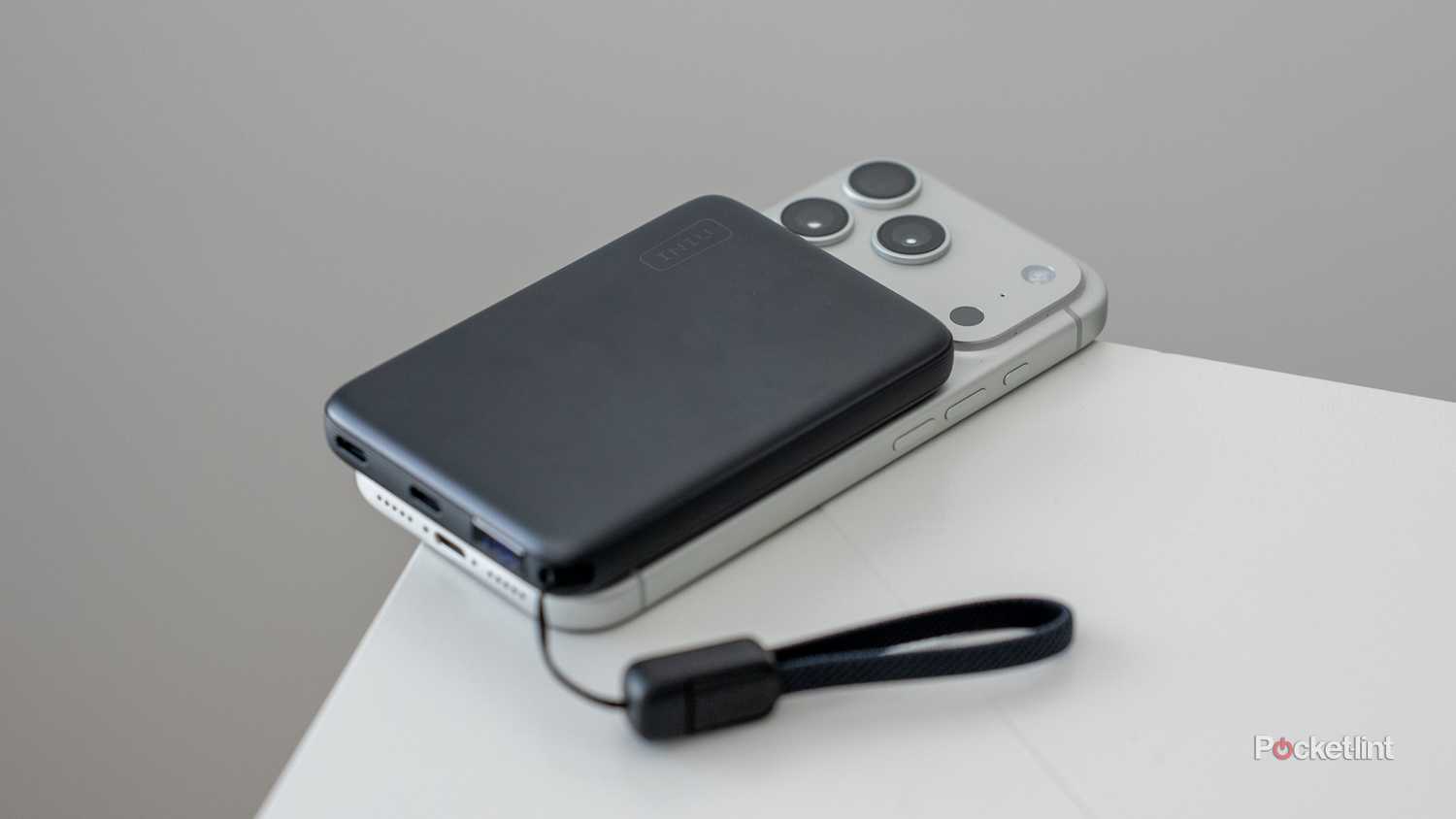 INIU SnapGo Air Power Bank front face MagSafe attached to iPhone on white table.