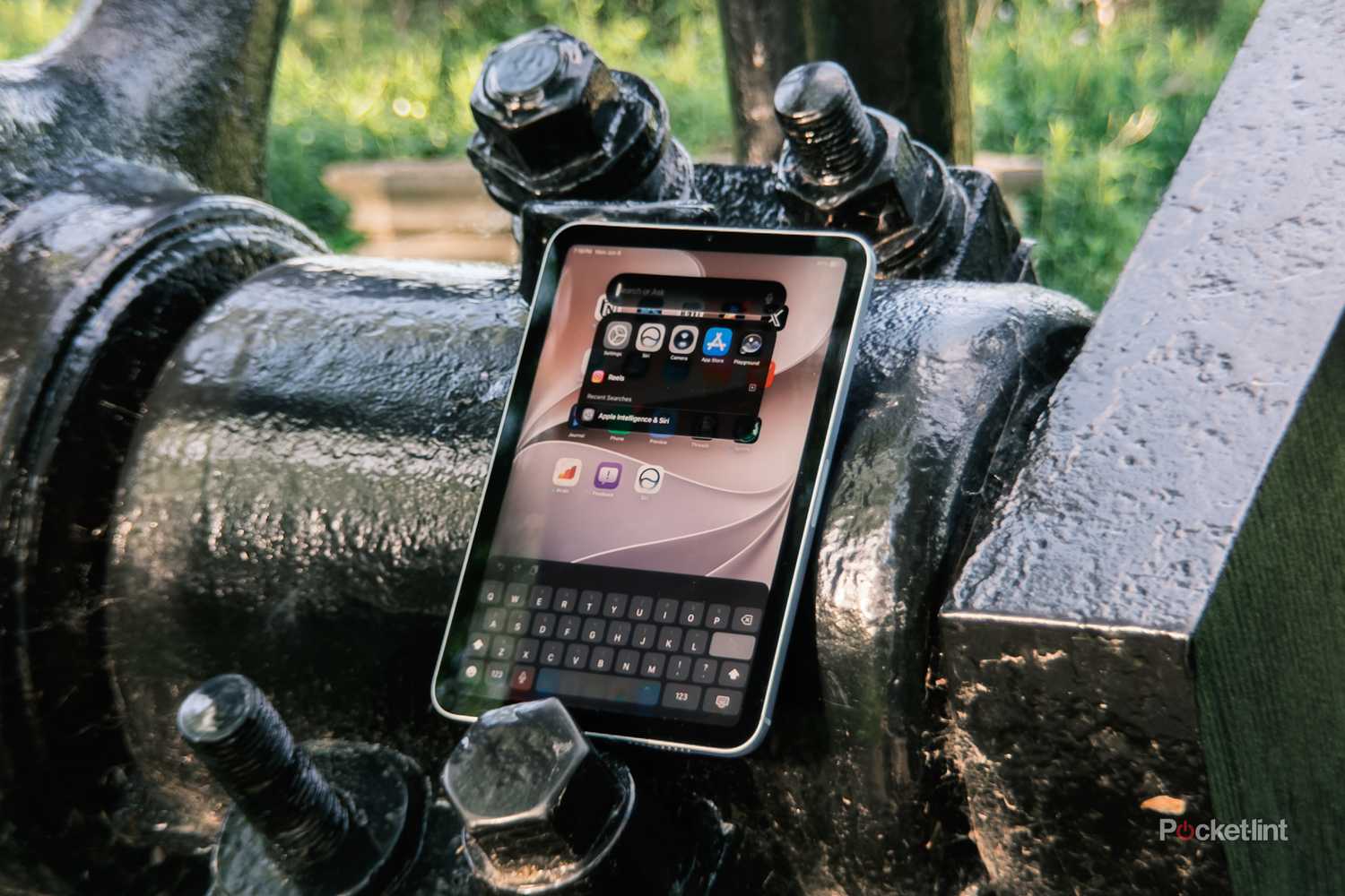 iPadOS 27 Spotlight Search on iPad Mini against industrial background-1