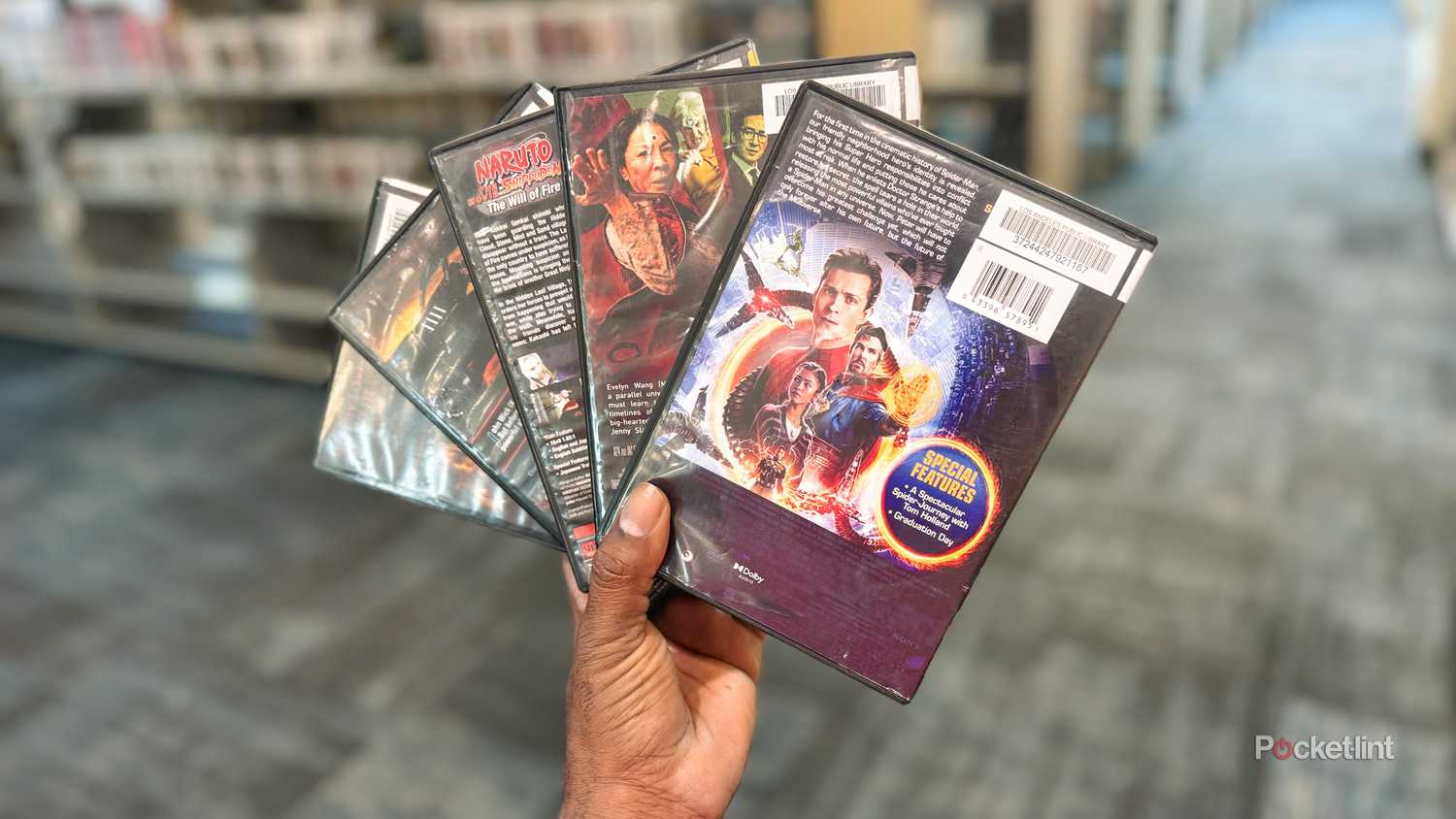 The writer of the article holding five DVDs in his hand, fanned out so you can see the back of their boxes