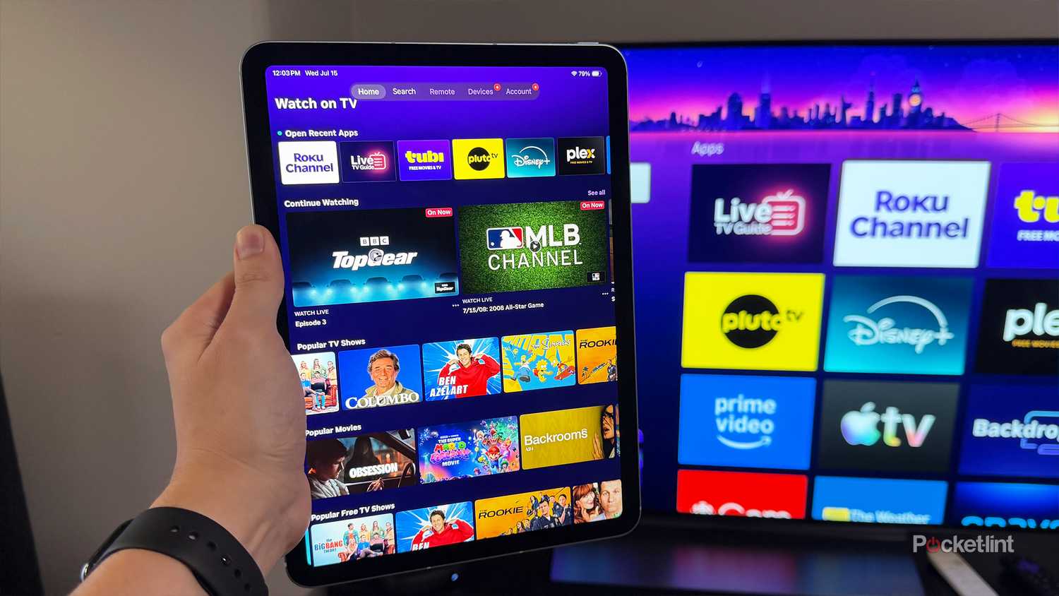 Person holding iPad Air next to TV with Roku Ultra.