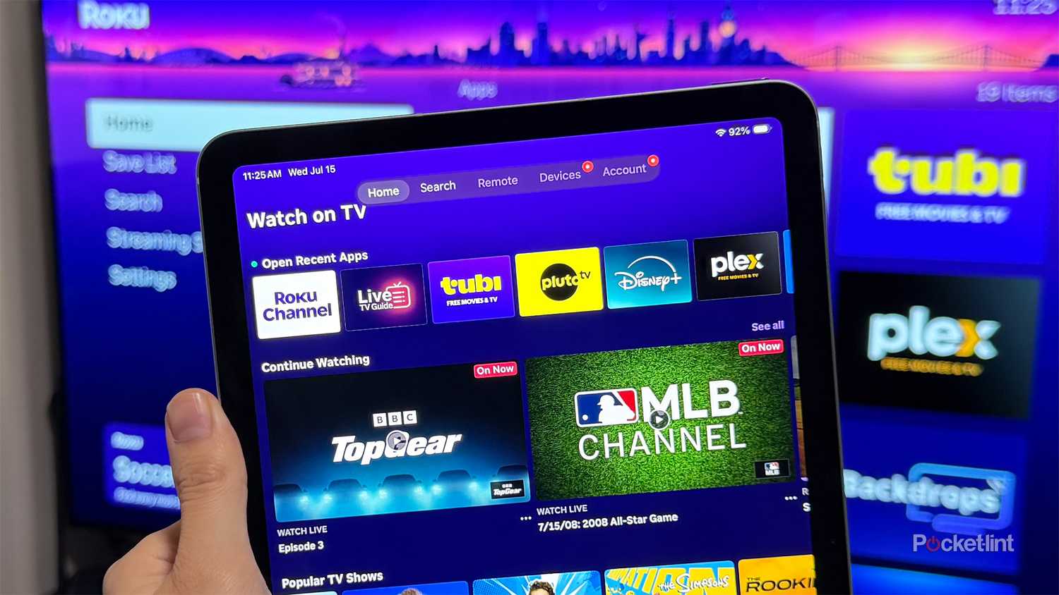 Person holding iPad in front of Roku TV.