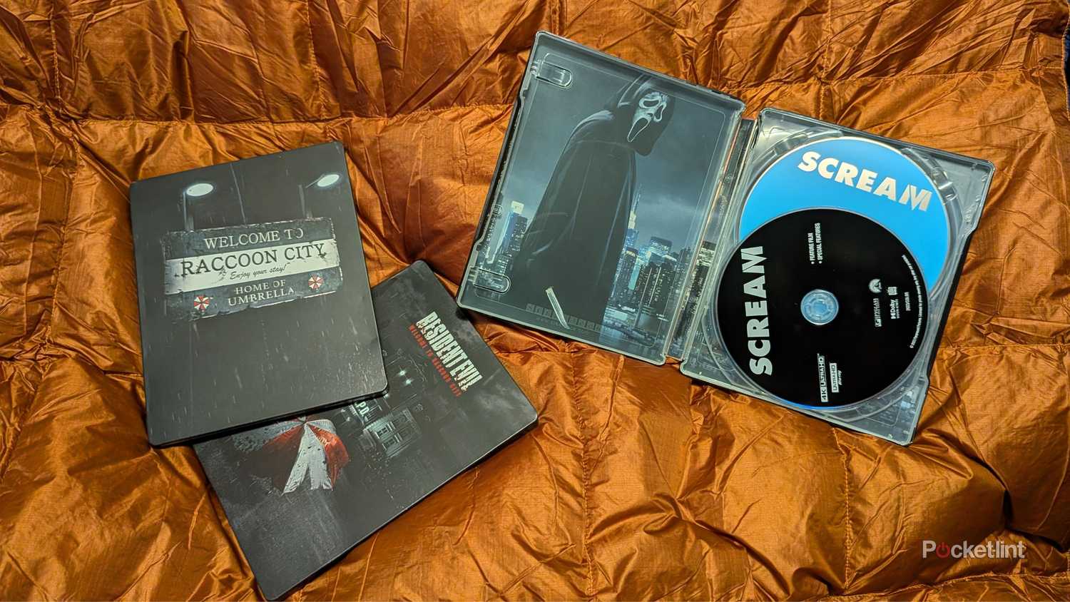 A pair of damaged steelbooks on an orange blanket.