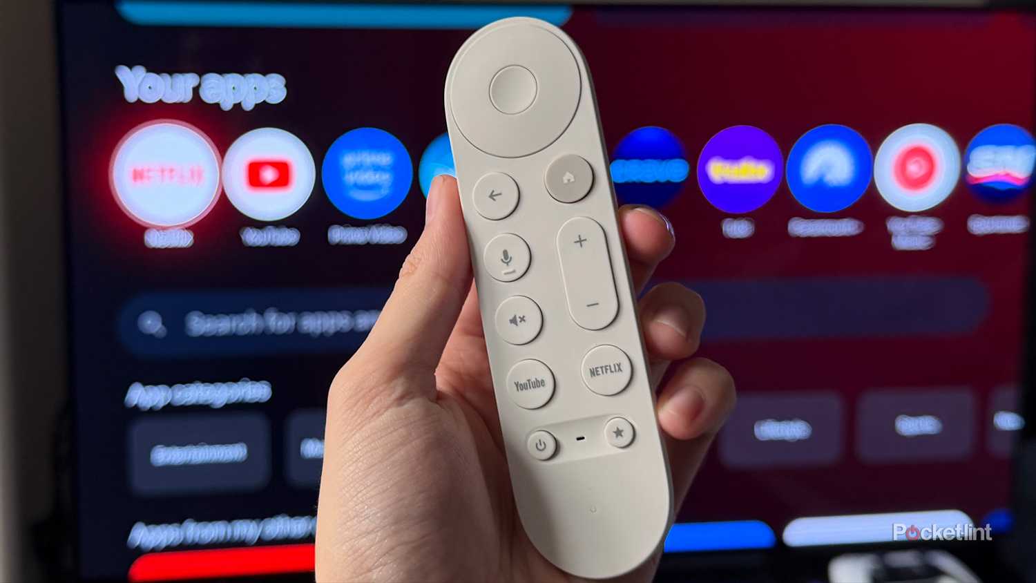 Person holding remote in front of Google TV.