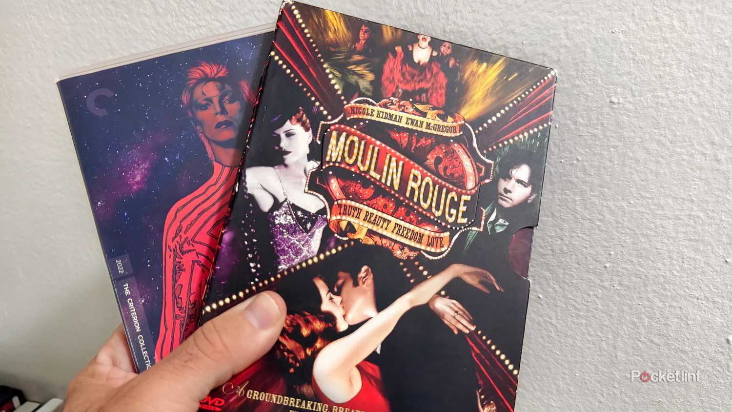 Hand holding physical copies of Moulin Rouge and Moonage Daydream