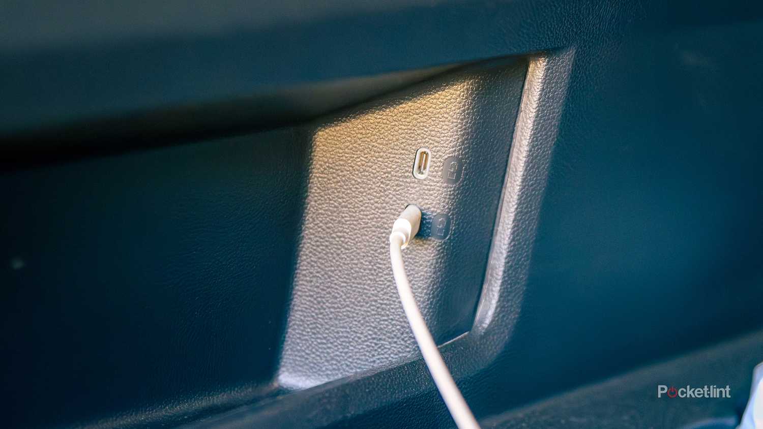 A still photo of a USB-C outlet in the back of a car.