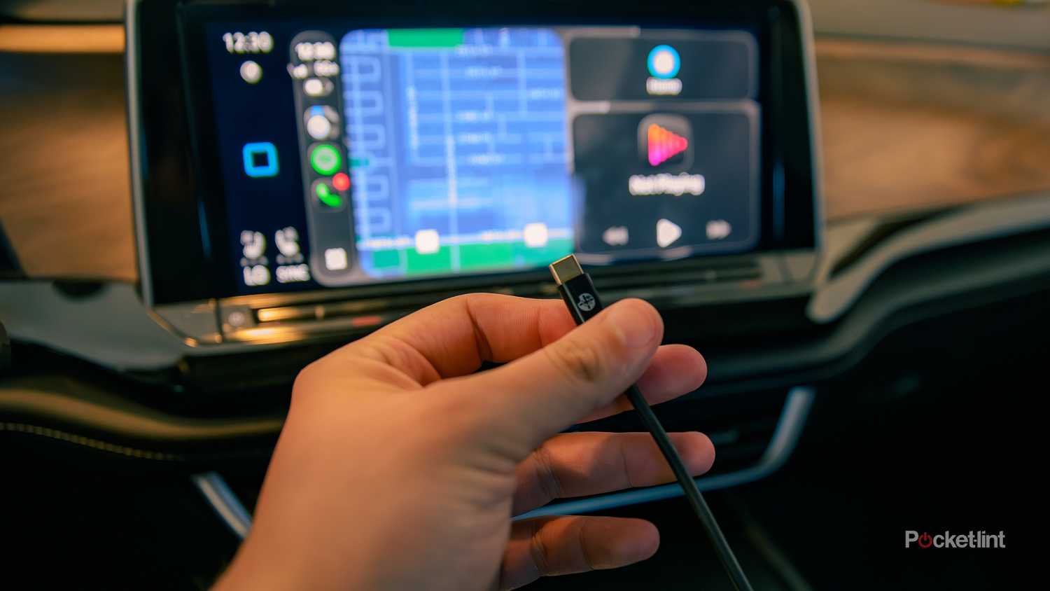 A still photo of a hand holding an Apple CarPlay USB-C connection cable.