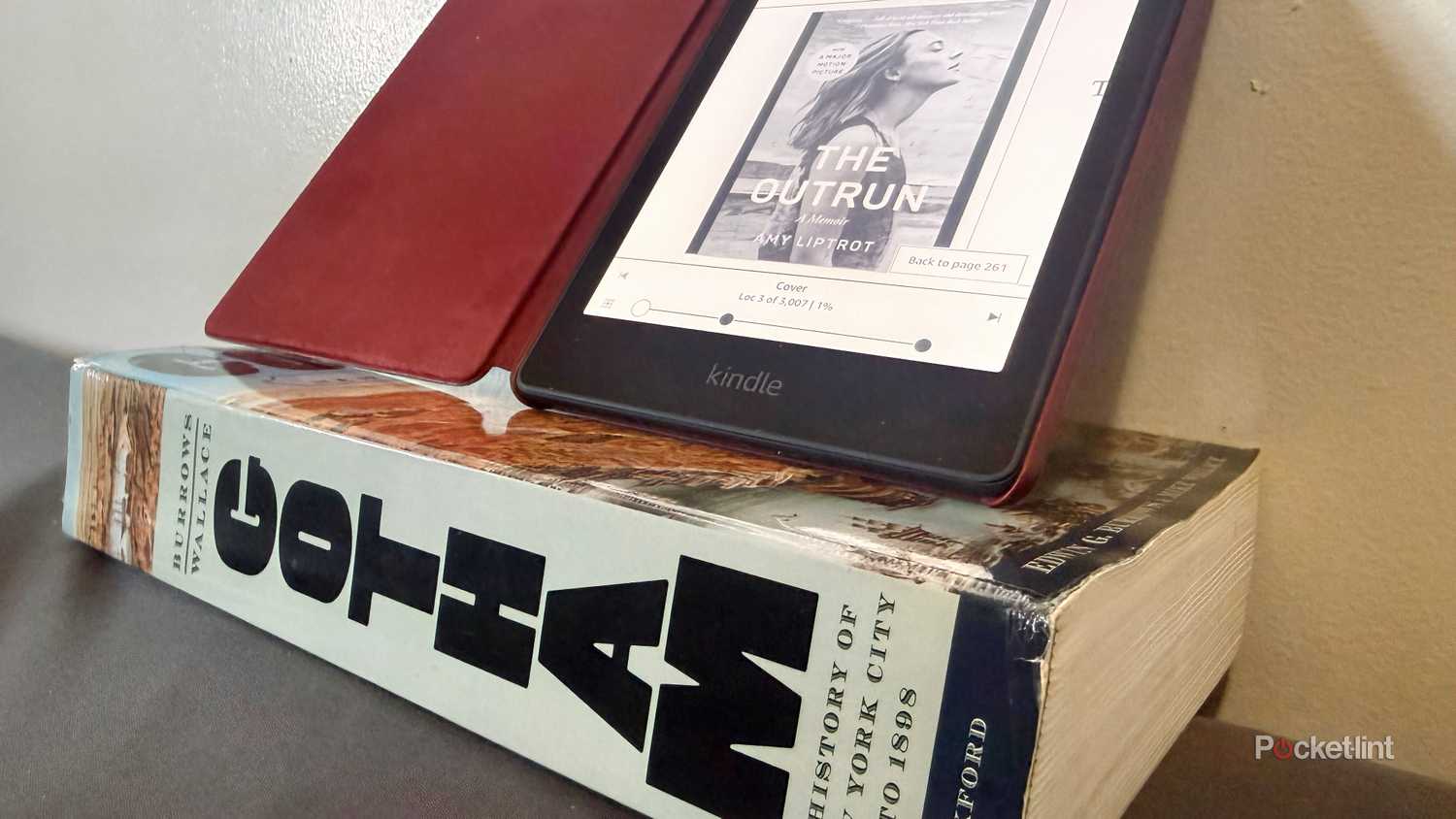Kindle e-reader on top of large book to display size difference.