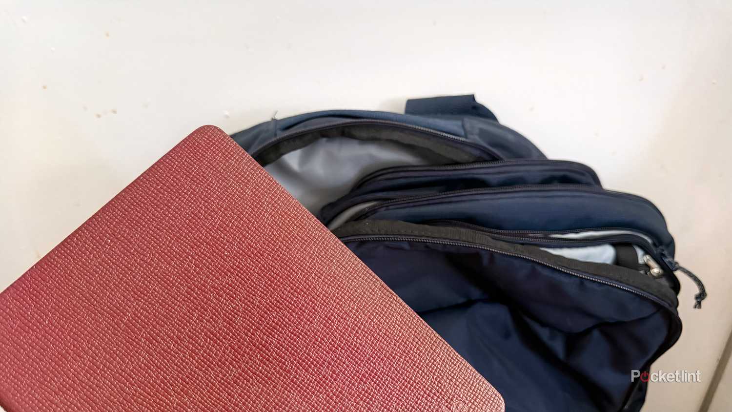 Kindle held in front of backpack.