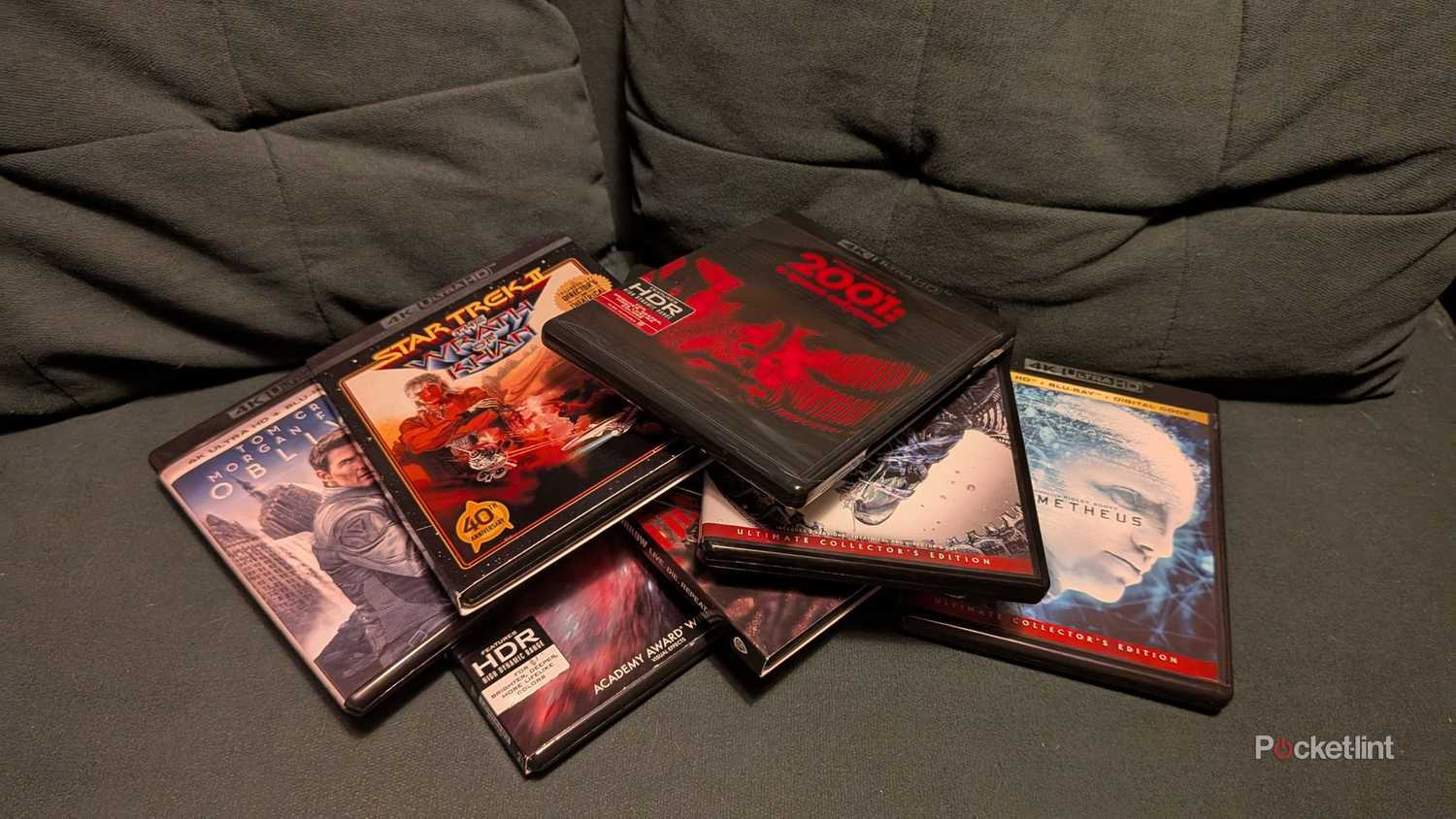 A pile of 4K Blu-ray discs on a couch.
